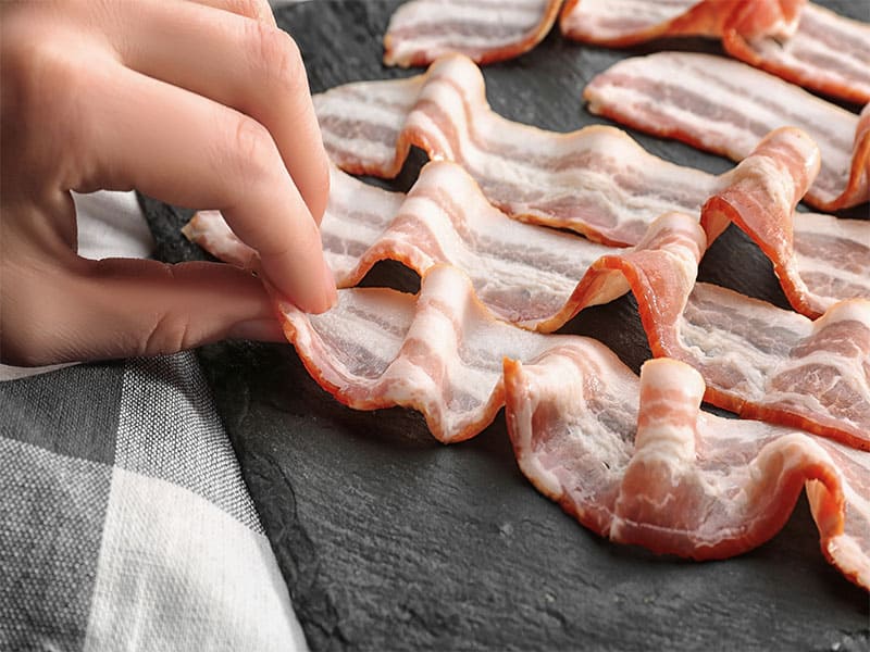 Hand Touching Strips Bacon