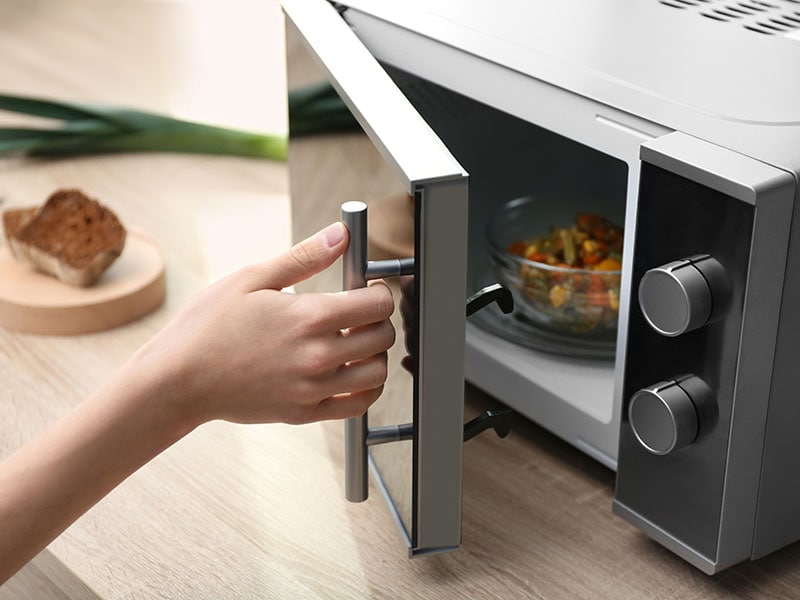 Woman Using Microwave Oven