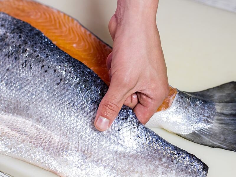 Hand Touches Raw Fish Meat