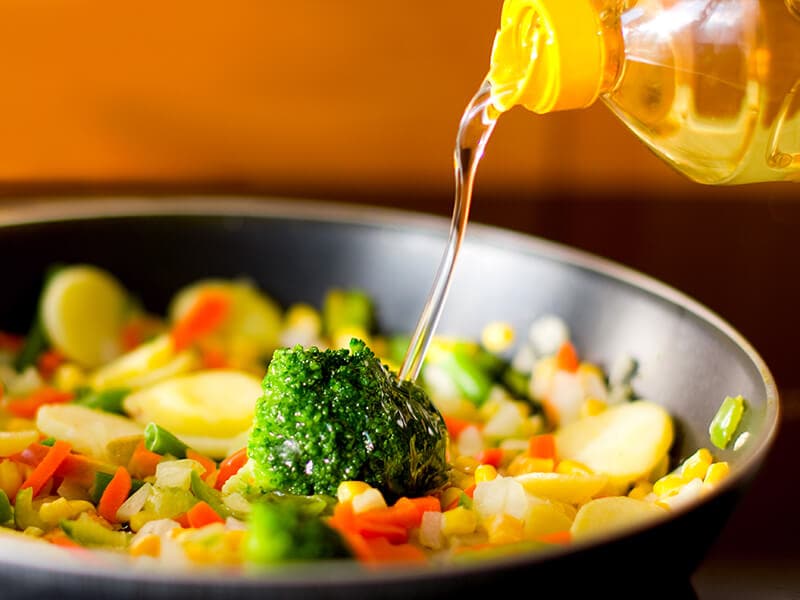 Pouring Oil Into Vegetable